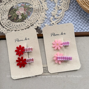 Detail of floral acetate hair claws with rhinestones and checkered ribbon on display card