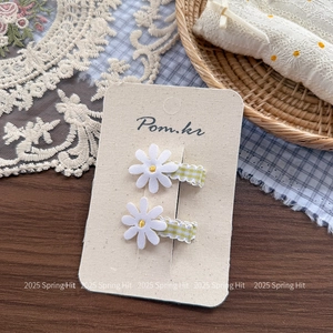Close-up of daisy hair clips with yellow gingham ribbon on a display card