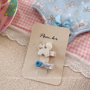 Détail de barrettes brodées chat et nœud bleu sur carte de présentation Pom.kr