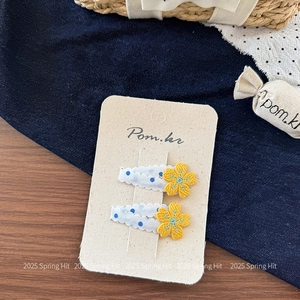 Detail von Kinder-Haarspangen mit gelber Blumenstickerei und blauen Polka Dots