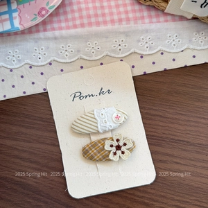 Dettaglio di set 2 fermagli per capelli da bambina con ricami e bottoni in stile country