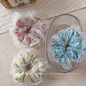 Vue détaillée de chouchous en tulle avec tissu fleuri et pois blancs