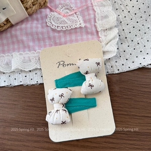 Close-up of sweet bow hair clips with brown polka dots on a blue ribbon base
