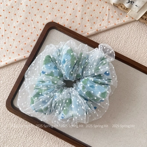 Détail d'un chouchou floral avec pois floqués blancs et couche de tissu en maille transparente