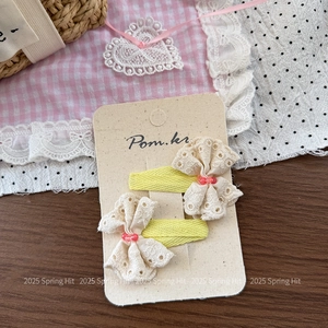 Detailed macro view of yellow fabric hair clips with lace bows and small red beads decoration