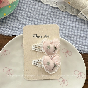 Gros plan de barrettes à cheveux en forme de cœur rose avec broderie et dentelle