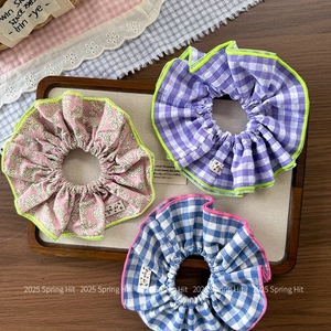 Three-piece set of floral and checkered scrunchies with ruffles on a wooden tray