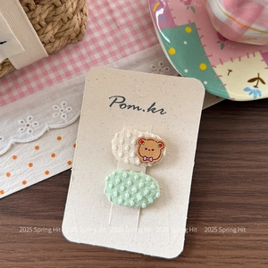 Détail de jolies barrettes à cheveux brodées d'ours et à pois pour filles sur carton