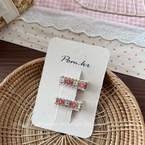 Dettaglio ravvicinato di fermagli per capelli ricamati a fiori con bordo in pizzo bianco