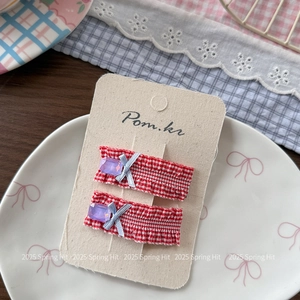 Detail of red gingham hair clips with lavender gemstones and silver ribbon bows