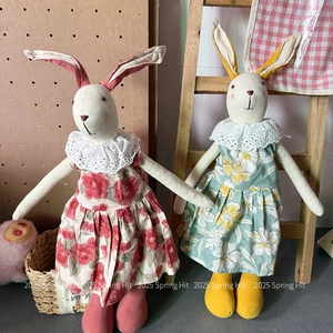 Macro shot of handmade cotton linen rabbit dolls with floral dresses and lace collars