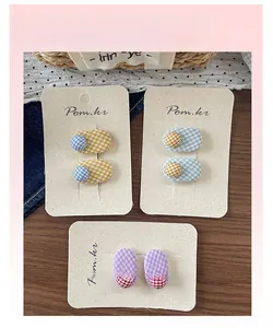 Detail of Korean plaid fabric hair clips with colorful polka dot beads on display card
