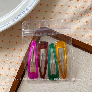 Set of four colorful acrylic teardrop hair clips in retail packaging for girls