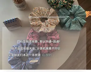 Close-up of four floral print cotton hair scrunchies with elegant botanical patterns