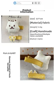 Détail d'une pince à cheveux en tissu avec broderie tête de chat blanche et ruban de satin jaune