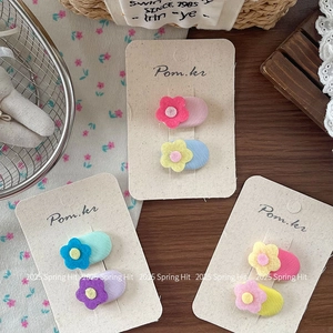 Handmade oval felt flower hair clips for girls in pastel colors on a display card