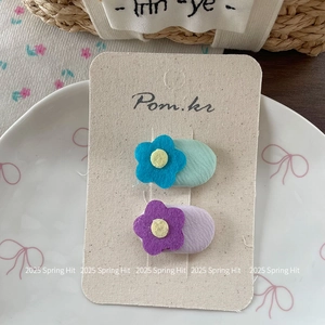 Close-up of sweet oval fabric flower hair clips set on display card in Korean style