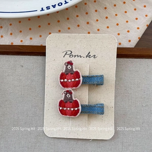 Détail de pinces à cheveux ours en denim avec broderie et perles blanches sur carte
