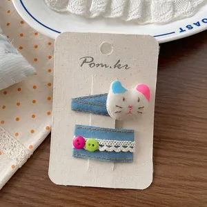 Detailansicht der Denim-Haarspangen mit Spitze und niedlichem Stoffkatzenkopf