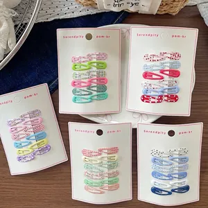 50-piece set of Korean style floral pattern snap hair clips for kids on wooden table