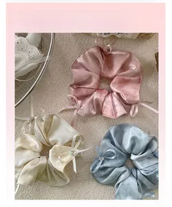 Close-up of silk scrunchies with elegant bow ties and shiny rhinestones detail