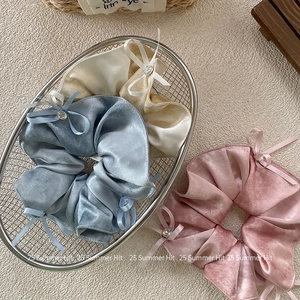 Three elegant bow scrunchies with crystal charms in blue, beige, and pink satin