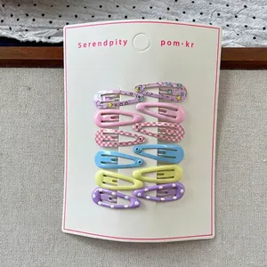 Close-up of 12-piece colorful patterned BB hair clips on white card display