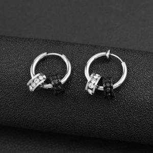 Elegant silver hoop earrings with clear and black rhinestone charms on dark background