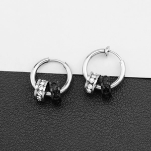 Polished silver titanium steel hoop earrings featuring crystal and black stone charms