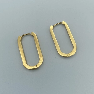 Macro shot of minimalist gold U-shaped oval hoop earrings with a secure clasp closure