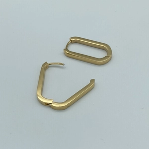 Flat lay macro of minimalist gold-plated titanium U-shaped geometric huggie hoop earrings