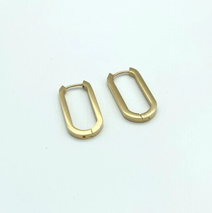 Detailed close-up of thick gold U-shaped hoop earrings with a secure hinged closure design