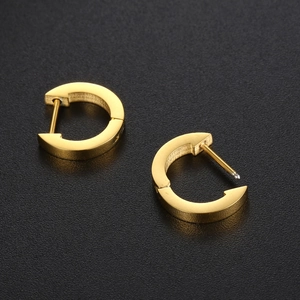 Minimalist gold titanium C-shape hoop earrings with smooth finish on black background
