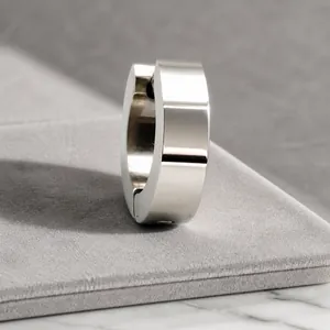 Dettaglio macro dell'orecchino huggie largo in acciaio inossidabile lucido argento