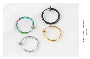Macro shot of punk spring clip earrings in silver, gold, black, and rainbow steel