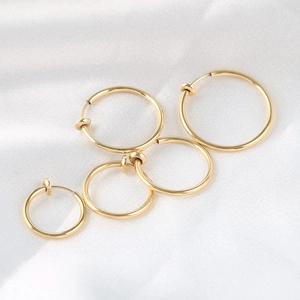 Golden punk spring hoop earrings for men in various sizes on white silk background