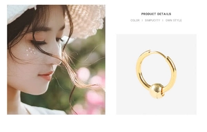 Detail of gold hoop earrings with small beads on a model and white background