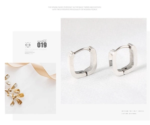 Detailed macro view of silver U-shaped stainless steel earrings with geometric hinges