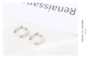 Detailed close-up of silver square tube geometric hoop earrings with polished finish