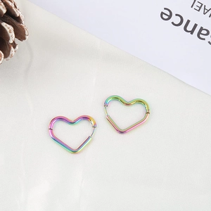 Regenbogen-Edelstahl-Herz-Ohrringe auf elegantem weißem Satin-Hintergrund