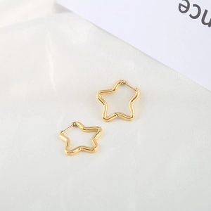 Polished gold pentagram star hoop earrings in stainless steel on white silk fabric