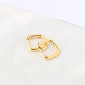 Polished gold square hoop earrings in titanium steel on elegant white silk background