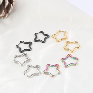 Polished star-shaped stainless steel hoop earrings in four metallic colors on white fabric