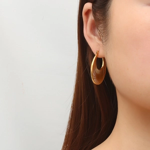 Luxurious 18k gold plated 304 stainless steel earrings with radiant texture on female model