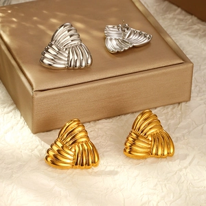Dettaglio di orecchini a triangolo in oro 18k e argento con texture a ventaglio