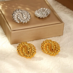 Dettaglio di orecchini a lobo grandi in oro e argento con design a bolle testurizzato