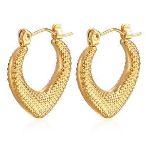 Close-up of 18K gold-plated U-shaped earrings with unique beaded texture and metallic finish