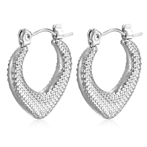 Detailed view of silver heart and V-shaped hoop earrings with hammered metal texture