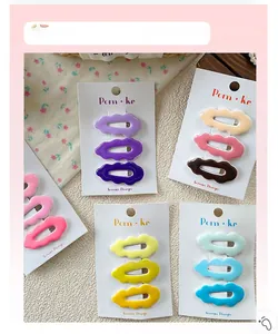 Close-up of pastel wavy hair clips set on display card with floral fabric background