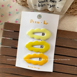 Three-piece set of wave-shaped resin hair clips in vibrant yellow gradient colors on card